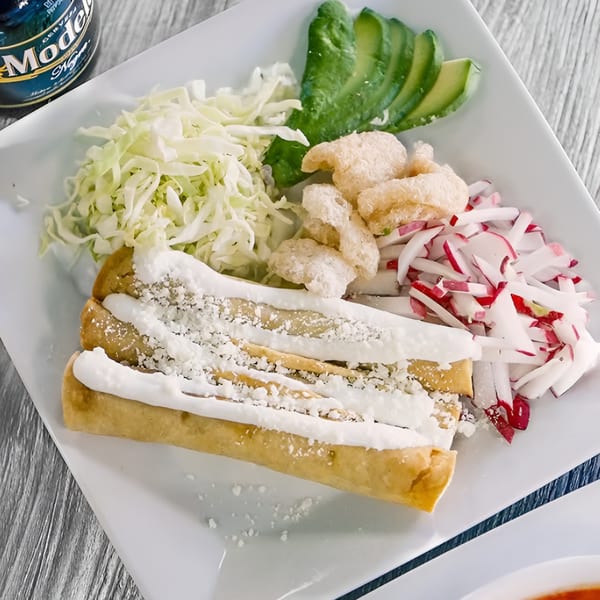 Taqueria Cuernavaca's taquitos with crema, cheese, shredded cabbage, avocado, chicharrones, and radishes.