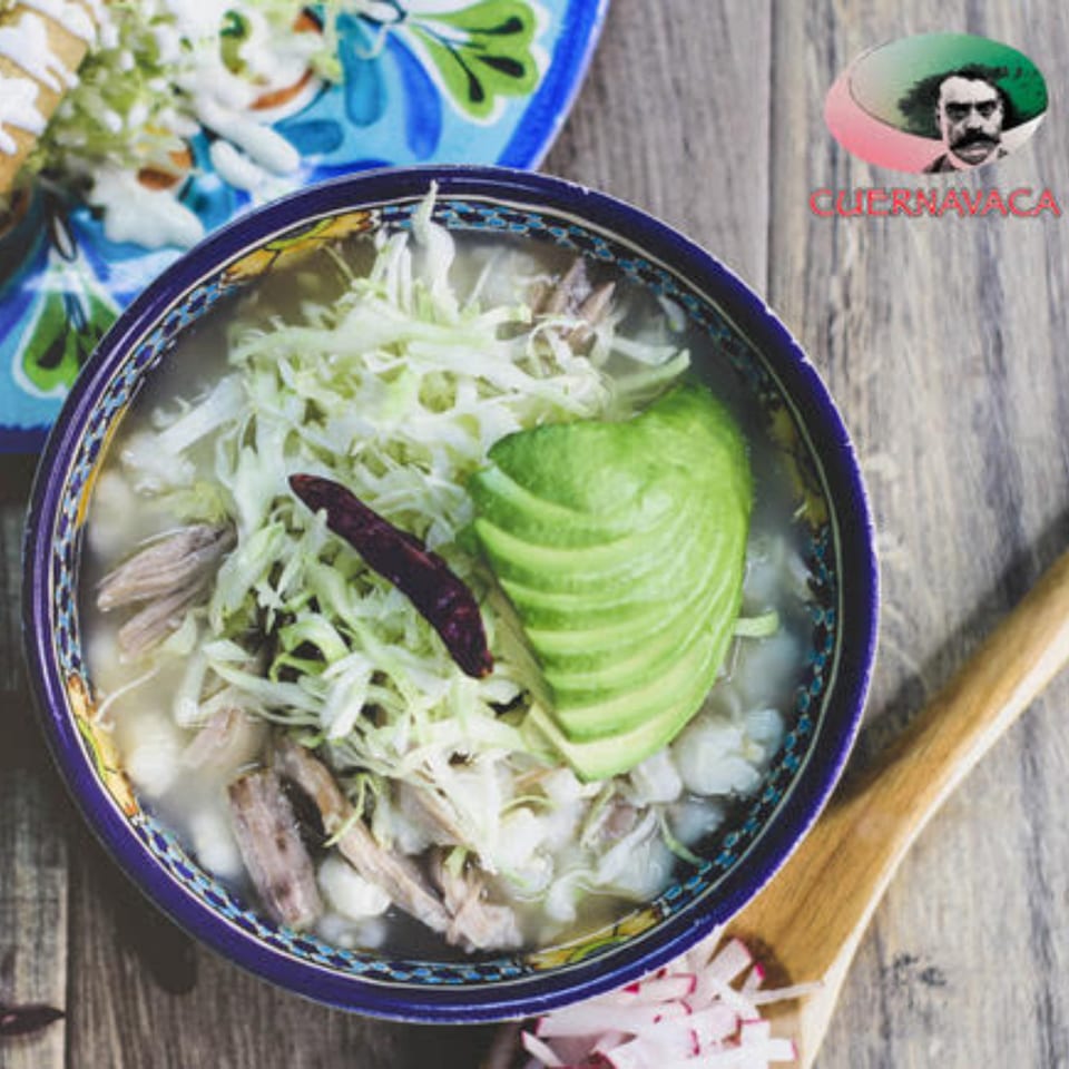 Pozole from Taqueria Cuernavaca, garnished with avocado, shredded cabbage, and a dried chili.
